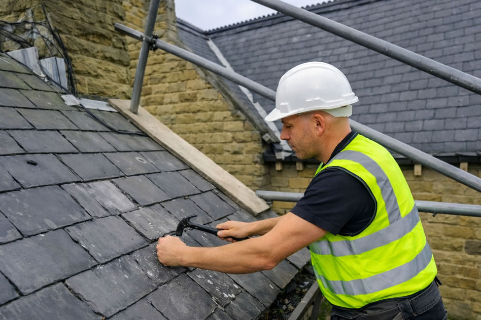 roofer repairing leaking slate roof